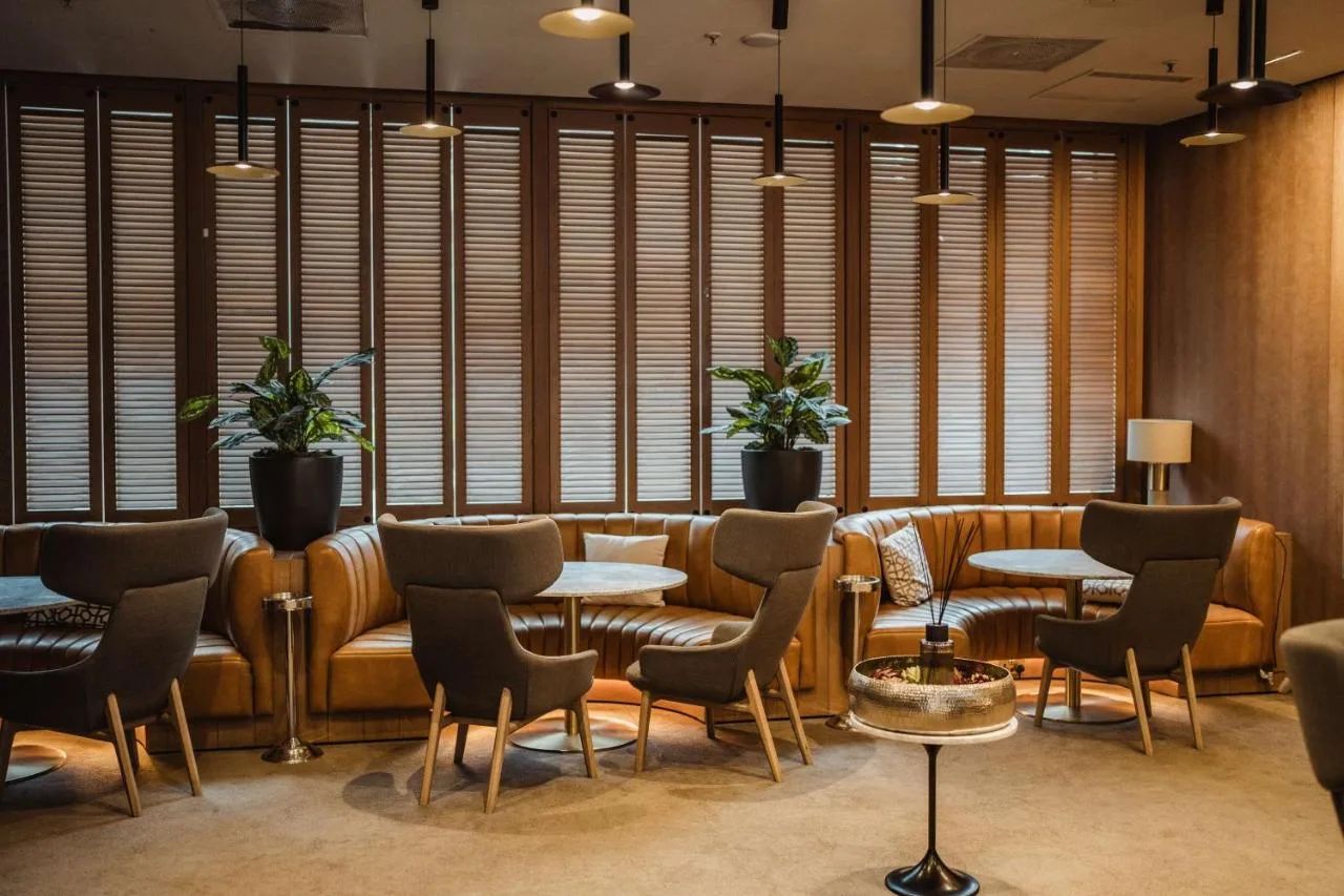 Lounge with tables, chairs and windows at Radisson Blu Hotel, Glasgow